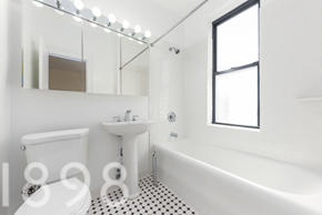 Woodside apartment for rent - A white bathroom with black and white tiles.