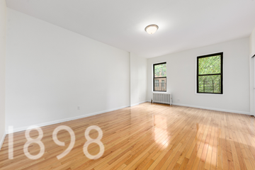 Woodside apartment for rent - A room with wooden floors and two windows.