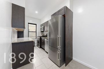 Sunnyside apartment for rent - A modern kitchen with a large refrigerator and a countertop.