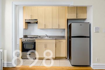 Woodside apartment for rent - A kitchen with wooden cabinets and a refrigerator.