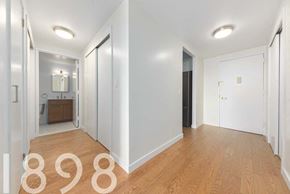 Jackson Heights apartment for rent - A hallway with a door on the right and a mirror on the left.