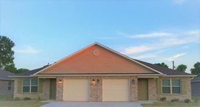 Siloam Springs triplex for rent - a brick house with two garage doors