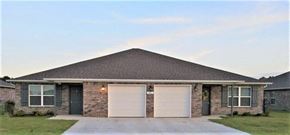 Bentonville apartment for rent - a brick house with two white garage doors