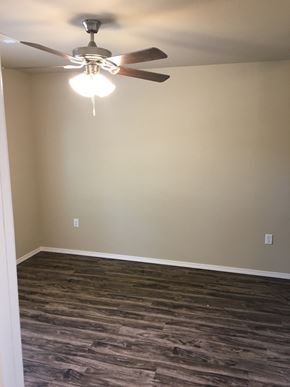 Siloam Springs triplex for rent - a living room with a ceiling fan and wood floor