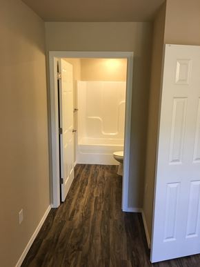 Siloam Springs triplex for rent - a bedroom with a door open to a bathroom with a toilet