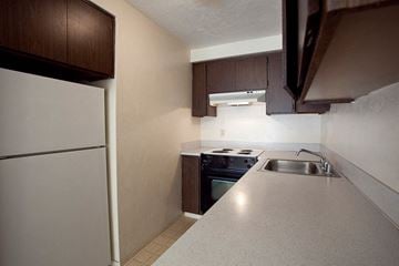 Eugene apartment for rent - A kitchen with a white fridge and a stove top oven.