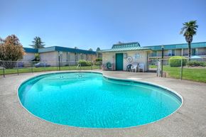 Eugene apartment for rent - A large outdoor swimming pool with a fence around it.