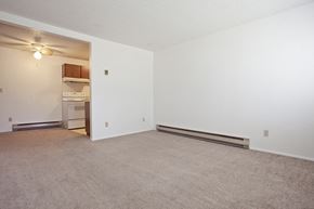 Bend apartment for rent - an empty living room with a kitchen in the corner