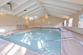 Bend apartment for rent - a swimming pool in a large room with chairs and a clock