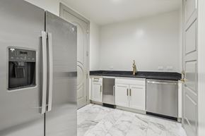 Houston apartment for rent - A kitchen with a stainless steel refrigerator and white cabinets.