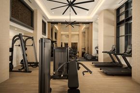 Dallas apartment for rent - A gym with a variety of equipment including treadmills, weights, and a television.