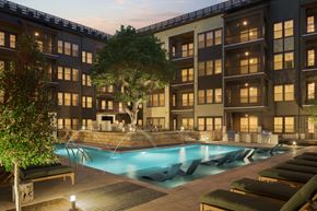 Austin apartment for rent - A large building with a pool in front of it.