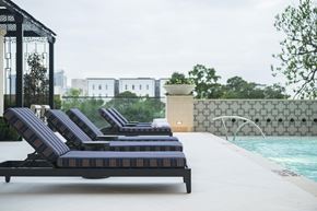 Houston apartment for rent - A poolside lounge area with striped sun loungers.
