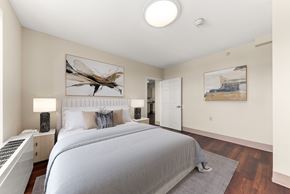 Spokane apartment for rent - A bedroom with a large bed and a painting of a dragonfly on the wall. at 206 Flats Apartments, Spokane, Washington