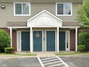 Romulus apartment for rent - a house with two blue doors and a porch
