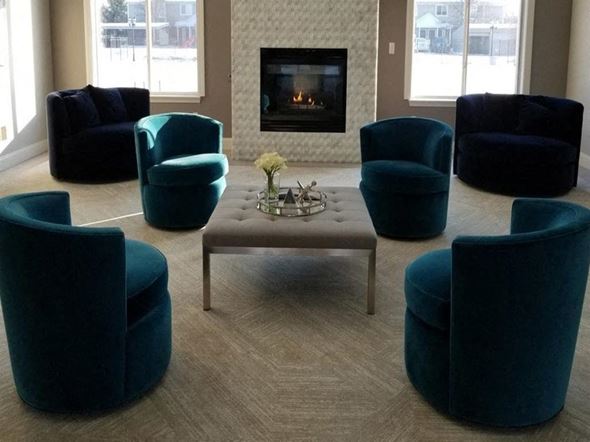 Romulus apartment for rent - a living room with blue chairs and a fireplace