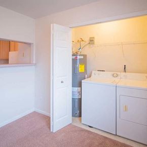 Romulus apartment for rent - a white laundry room with two washes and a dryer