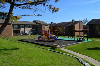 Community playground with slides and nearby pergola