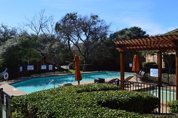 Swimming pool with pergola seating and closed umbrellas