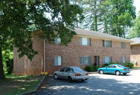 Atlanta apartment for rent - Two cars parked in front of a brick building.