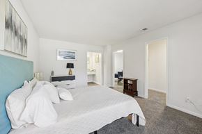 Clarkston apartment for rent - A bedroom with a large bed and a painting on the wall.