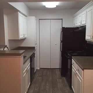 Lawrenceville apartment for rent - A kitchen with white cabinets and a black fridge.