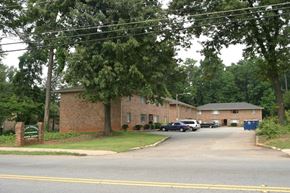 Atlanta apartment for rent - A brick building with a green sign in front of it.