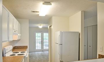 Lilburn apartment for rent - A kitchen with white cabinets and a white stove top oven.