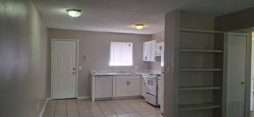 Pensecola apartment for rent - A kitchen with white cabinets and a white door.
