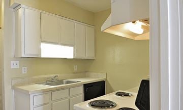 Clarkston apartment for rent - A kitchen with a white stove top oven and white cabinets.