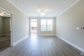Asheville apartment for rent - an empty living room with a ceiling fan and a window