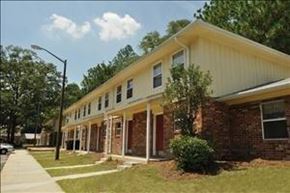 Statesboro apartment for rent - A two-story building with a yellow top and a brick bottom.