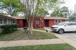 Pensecola apartment for rent - A red building with a white car parked in front.