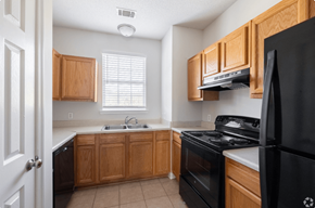 Pembroke apartment for rent - A kitchen with black appliances and wooden cabinets.