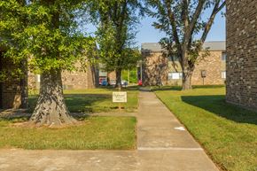 Greenville apartment for rent - a path with a sign in the middle of a grassy area with trees