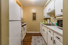 Greenville apartment for rent - a kitchen with white cabinets and white appliances