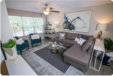Stockbridge apartment for rent - A living room with a grey couch, a coffee table, and a ceiling fan.