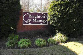 Douglasville apartment for rent - A sign that says Brighton Manor in front of some bushes.