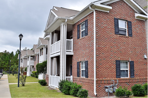 Hinesvile apartment for rent - A row of red brick houses with white trim and black shutters.