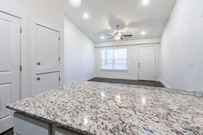 Bentonville apartment for rent - A spacious room with a granite countertop and a ceiling fan.