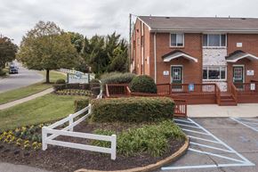 Norfolk apartment for rent - A red brick building with a white fence in front.