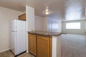 Norfolk apartment for rent - A kitchen with a white refrigerator and wooden cabinets.