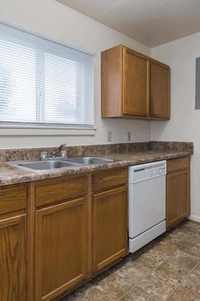 Norfolk apartment for rent - A kitchen with wooden cabinets and a white dishwasher.
