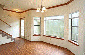 Yukon townhouse for rent - an empty living room with hardwood floors and a chandelier