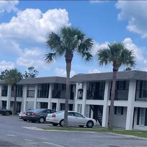 Sulphur apartment for rent - a building with two palm trees in front of it