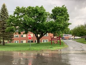 Caribou apartment for rent - a building with a stop sign in front of a tree