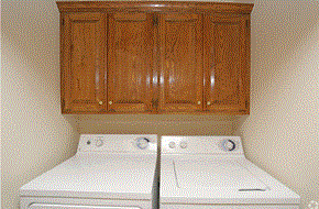 Yukon townhouse for rent - a laundry room with white appliances and wooden cabinets