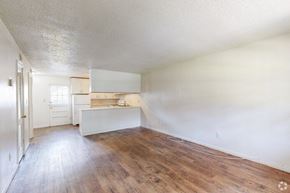 Pensacola apartment for rent - an empty living room and kitchen with wood floors