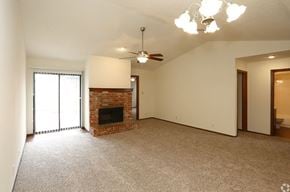 Oklahoma City townhouse for rent - a living room with a fireplace and a ceiling fan
