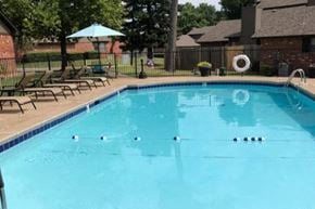 Oklahoma City townhouse for rent - a swimming pool with chairs and a fence around it